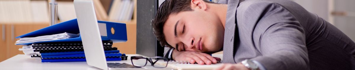 A man oversleeping on his desk at work - Intus Healthcare