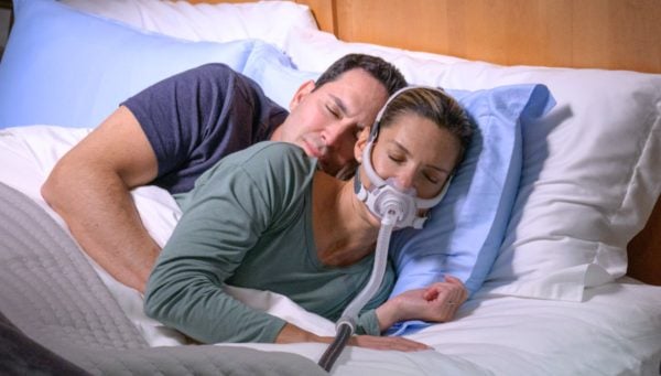 Woman wearing ResMed AirFit F40 CPAP Mask in bed | Intus Healthcare