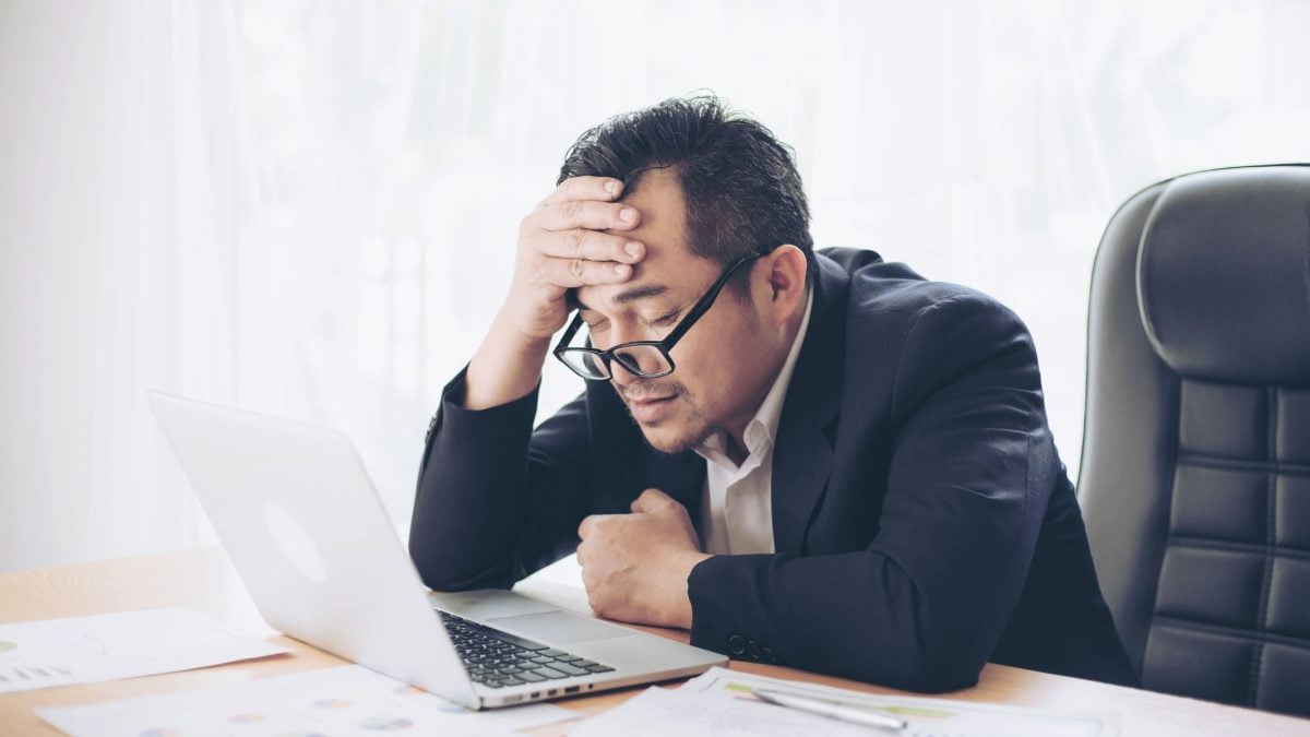 Man sitting at desk holding his, always tired | Intus Healthcare