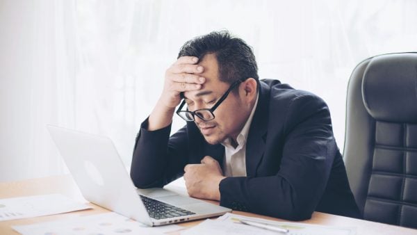 Man sitting at desk holding his, always tired | Intus Healthcare