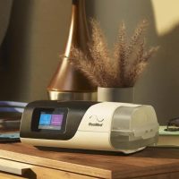 ResMed AirSense 11 Auto CPAP Machine on bedside table with mask | Intus Healthcare