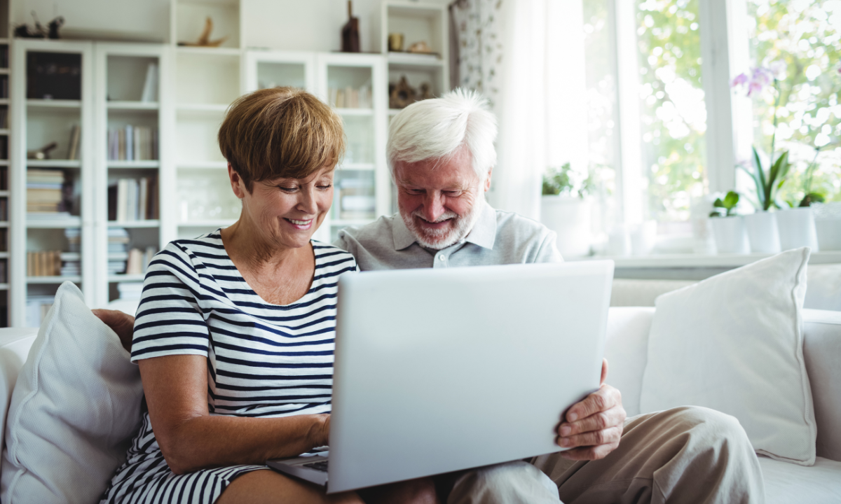 Older couple smiling over a laptop