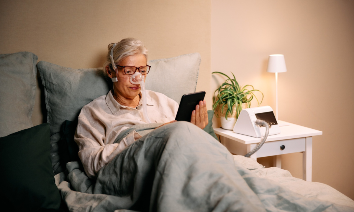 Woman sitting comfortably using her Prisma CPAP machine